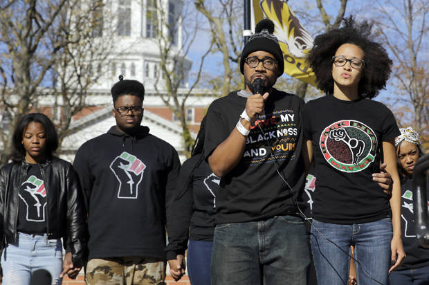 Jonathan Butler, center, addresses a crowd following the announcement that University of Missouri System President Tim Wolfe would resign Monday, Nov. 9, 2015, at the university in Columbia, Mo. Butler has ended his hunger strike as a result of the resignation. (AP Photo/Jeff Roberson)