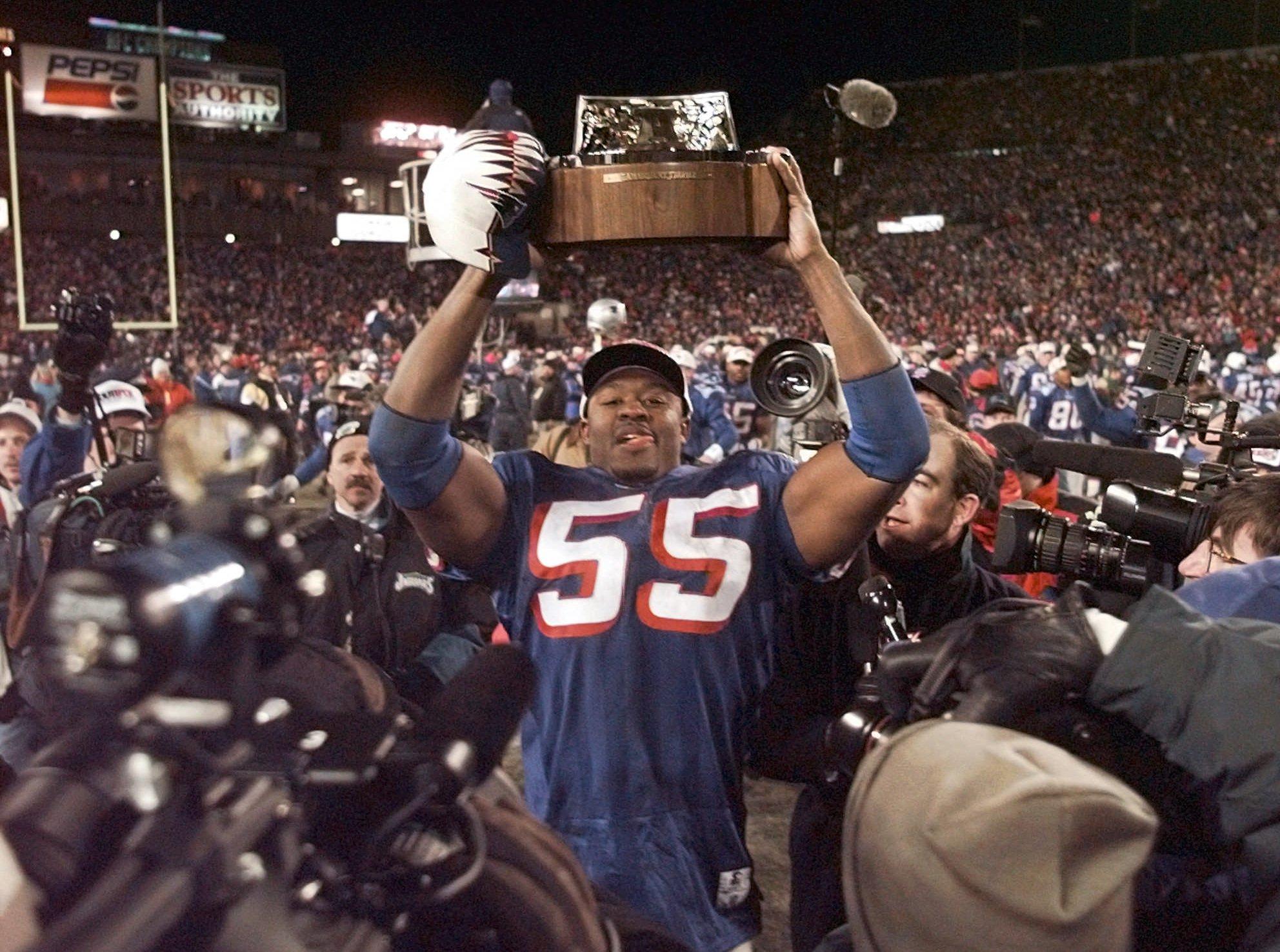 New England Patriots Willie McGinest holds the AFC Championship trophy after the Pats beat the Jacksonville Jaguars 20-6 at Foxboro Stadium in Foxboro, Mass., Sunday, January 12, 1997. (AP Photo/Doug Mills)
