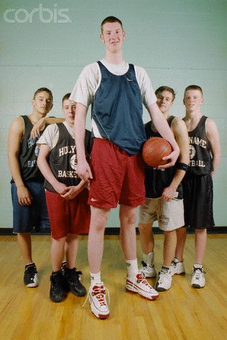 ca. 2000, Worcester, Massachusetts, USA --- Neil Fingleton (7'6") with his basketball team at Holy Name Central Catholic High School. He now plays center for Holy Cross College. --- Image by © Michael Brennan/CORBIS